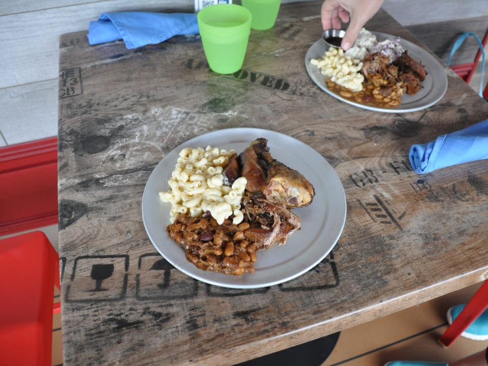 An overhead photo of two dishes loaded with barbecue foods.