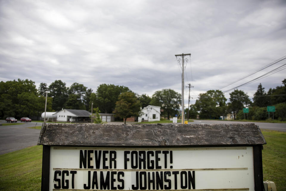A sign remembering Sgt. James Johnston, who was killed in Afghanistan in June, stands outside the American Legion hall in Trumansburg, N.Y., Sunday, Sept. 1, 2019. As the nation's longest war marks the end of its 18th year, James' widow, Krista Johnston, returned to her tiny hometown for two milestones: In one weekend at the hall, she joined hundreds to pay tribute to her husband with a 21-gun salute, TAPS and remembrances. A day later, she returned for a baby shower, celebrating the impending birth of their daughter he didn't live to see. The little girl will be named for her father. (AP Photo/David Goldman)