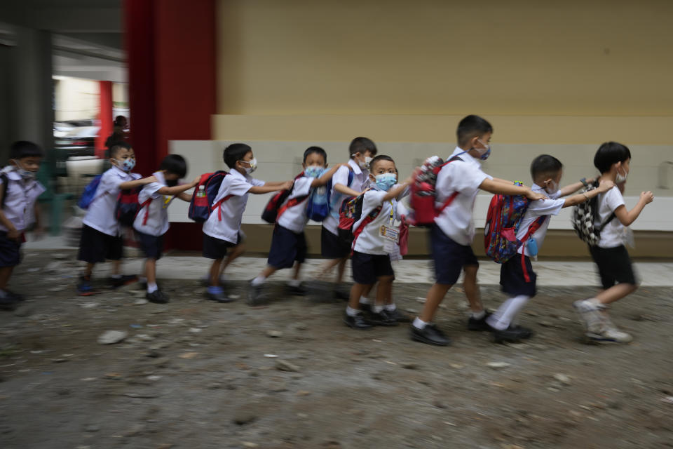 Students fall in line during the opening of classes at the San Juan Elementary School in metro Manila, Philippines on Monday, Aug. 22, 2022. Millions of students wearing face masks streamed back to grade and high schools across the Philippines Monday in their first in-person classes after two years of coronavirus lockdowns that are feared to have worsened one of the world's most alarming illiteracy rates among children. (AP Photo/Aaron Favila)