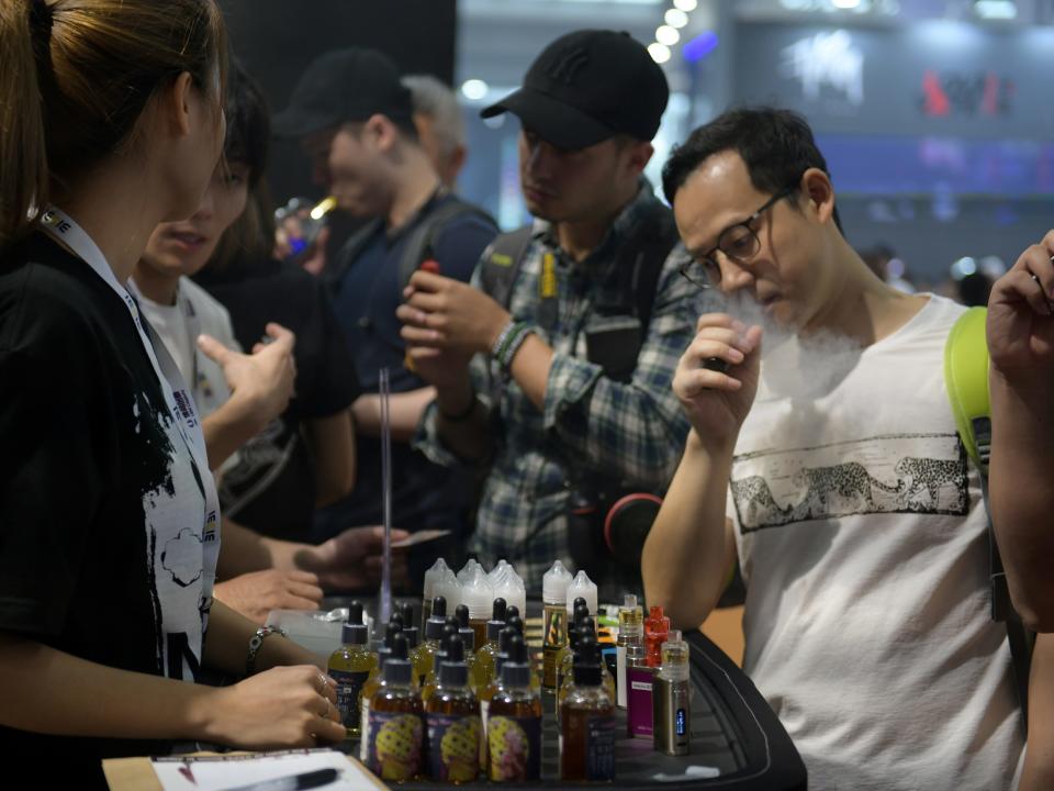 FILE PHOTO: Visitors try out e-cigarette products at a booth during the eCig Expo (IECIE) in Shenzhen, Guangdong province, China April 14, 2019.  REUTERS/Stringer
