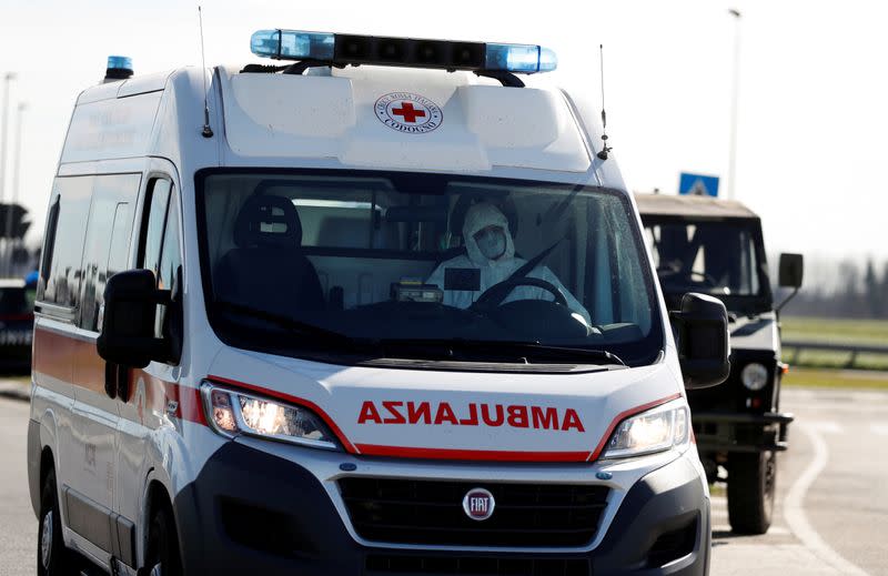 A man wearing a protective face mask drives an ambulance as he leaves the cordoned area in a "check-point six", few kilometers from the small town of Castiglione d'Adda