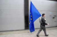 A man carries a European Union flag near the London School of Economics in London
