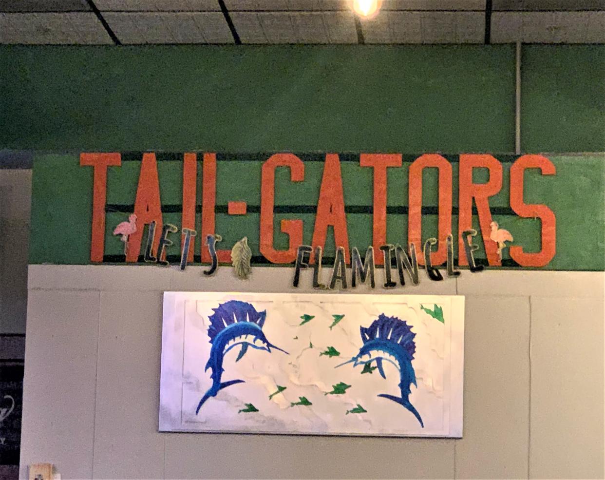 Tail Gators is a Florida-style family-friendly sports bar encircled with 25 wall-to-wall flat-screen televisions, sports team flags, banners, and colorful fish art.