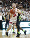 Wisconsin guard Brad Davison (34), defended by Michigan State guard Rocket Watts, attempts a layup during the first half of an NCAA college basketball game, Friday, Jan. 17, 2020, in East Lansing, Mich. (AP Photo/Carlos Osorio)