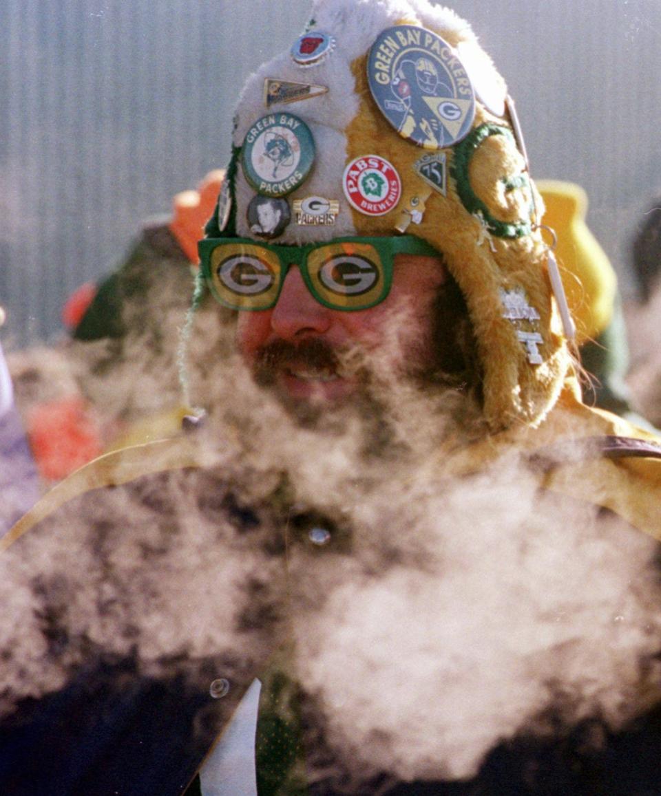 FILE - In this Jan. 12, 1997, file photo, Green Bay Packers fan Gregg Matuszak of Pulaski, Wis., is bundled up against the cold while waiting to enter Lambeau Field for the start of the NFC Championship game between the Packers and the Carolina Panthers, in Green Bay, Wis. Instead of shrinking from the possibility that football’s ultimate championship could be played in a blizzard, organizers of the first outdoor, cold-climate Super Bowl have decided to embrace the snow as the game’s unofficial theme. That could be cold comfort to the throngs of visitors to the New York City area for Super Bowl week, and to the 82,000-plus fans who will actually brave the elements during the Feb. 2 game at open-air Met Life Stadium in East Rutherford, N.J.(AP Photo/Todd Ponath, File) ORG XMIT: NY155