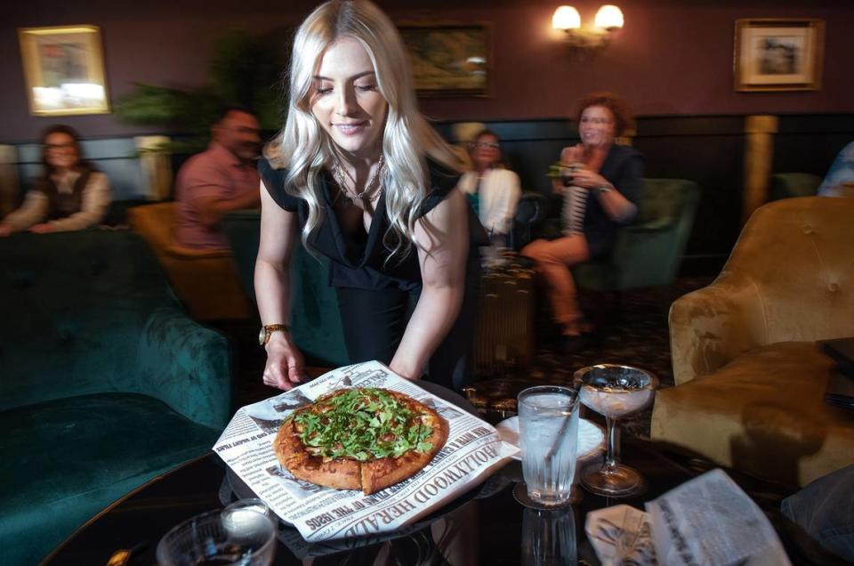 Server Katie Sperbeck delivers a pizza at the Falcon’s Lair in Ripon, Calif., Thursday, March 30, 2023.