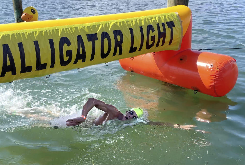 In this photo provided by the Florida Keys News Bureau, swimmer Connor Signorin, 31, heads to the finish line to win top individual honors at at the Swim for Alligator Lighthouse open-water challenge Saturday, Sept. 9, 2023, in Islamorada, Fla. It was the third consecutive win for Signorin. A Tampa, Fla., resident, the former University of Florida swimmer who won All-American honors five times, finished in 2 hours, 59 minutes and 44 seconds, a personal best for him. The event helps raise funds to restore Alligator Reef Lighthouse, one of six aging Florida Keys lighthouses. (Andy Newman/Florida Keys News Bureau via AP)