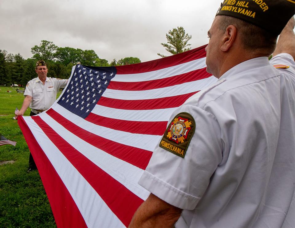Red Hill VFW Post 5954 member Bob Aberdine, left, and, Post Commander Thomas Sally fold the American flag during the funeral of veteran John Williams, at the Fairview Cemetery in Willow Grove, on Friday, May 27, 2022. Williams' remains ended up in the custody of the Montgomery County Coroner's Office following his death in December. Employees there found that he had a pre-purchased cemetery plot next to his mother's grave, and made arrangements to see that his final wishes were met.