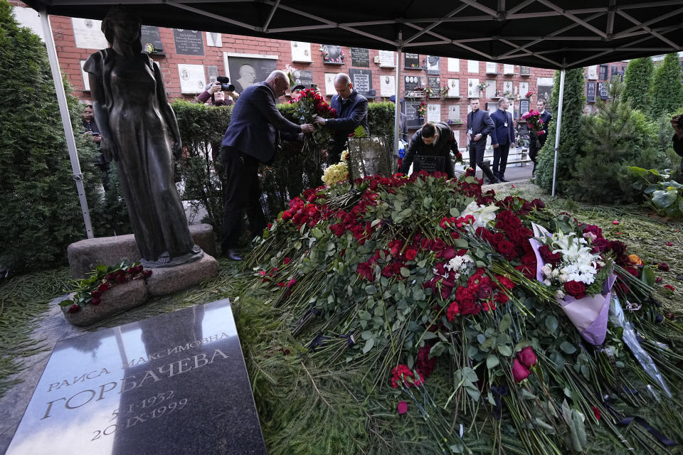 People lay flowers on the grave of former Soviet President Mikhail Gorbachev during his funeral at Novodevichy Cemetery in Moscow, Russia, Saturday, Sept. 3, 2022. (AP Photo/Alexander Zemlianichenko, Pool)