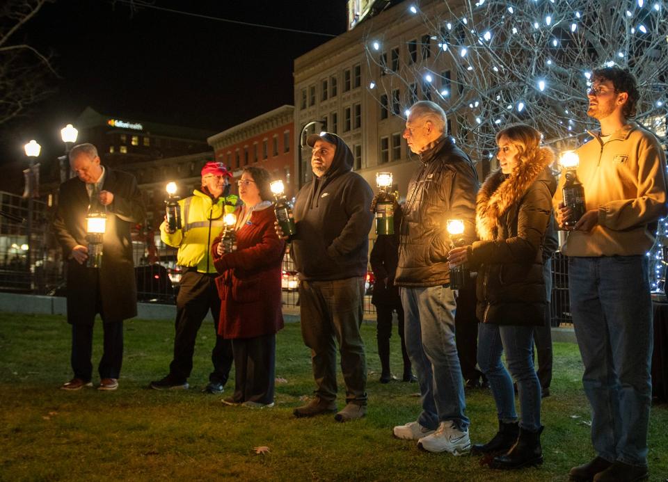Members of the community chosen to place a light on the menorah listen as a blessing is recited Tuesday on the Worcester Common.