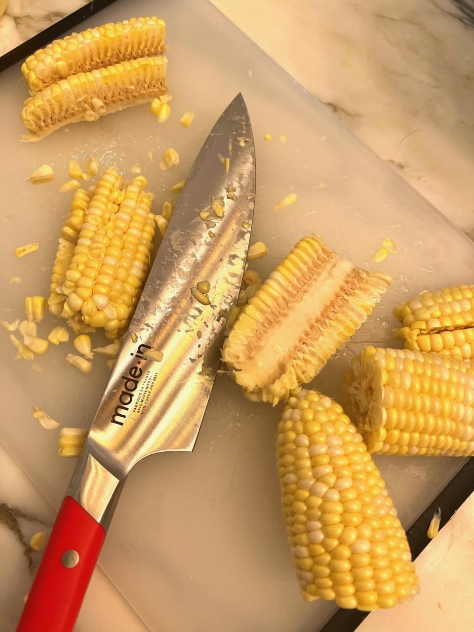 A cutting board and pieces of corn