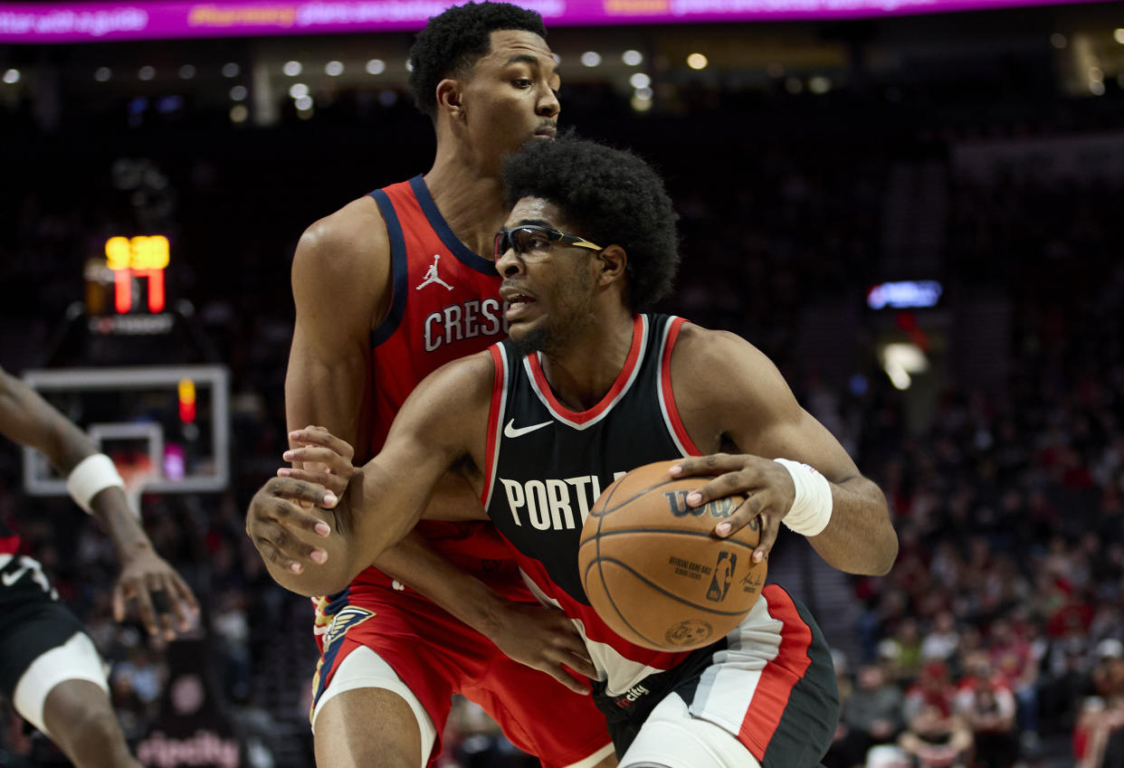 Portland Trail Blazers guard Scoot Henderson, right, dribbles around New Orleans Pelicans guard Trey Murphy III during the first half of an NBA basketball game in Portland, Ore., Tuesday, April 9, 2024. (AP Photo/Craig Mitchelldyer)