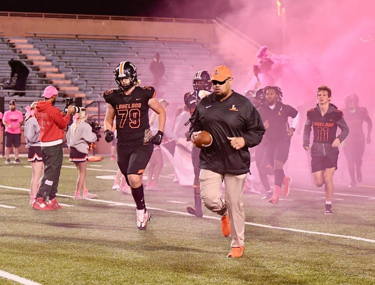 Lakeland coach Marvin Frazier runs onto the field during the 2022 season.