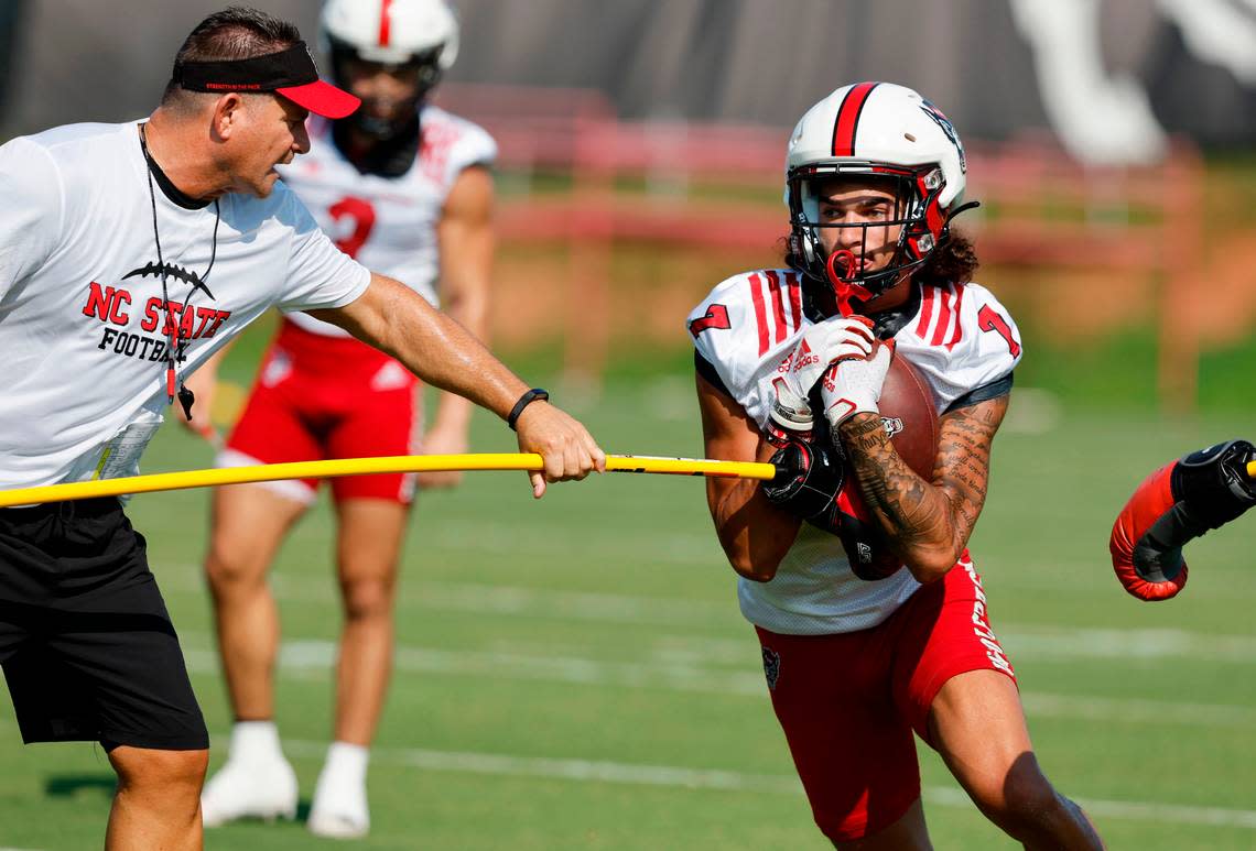 N.C. State offensive coordinator Tim Beck works with wide receiver Anthony Smith (7) during the Wolfpack’s first practice of fall camp in Raleigh, N.C., Wednesday, August 3, 2022.