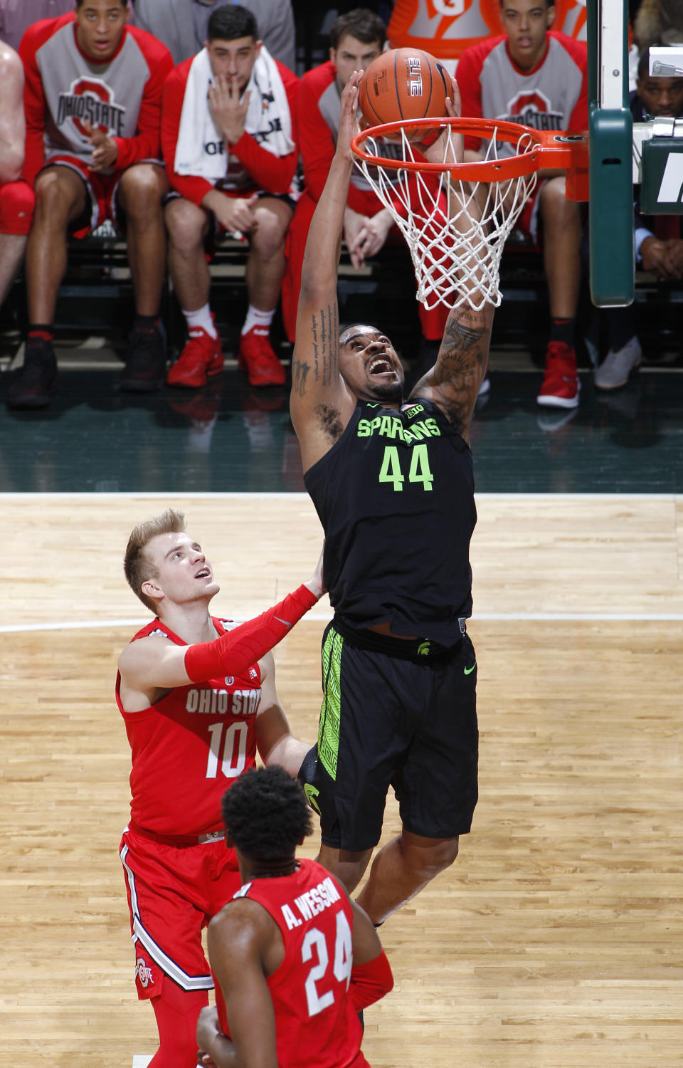 Michigan State's Nick Ward (44) goes up for a dunk against Ohio State's Justin Ahrens (10) and Andre Wesson (24) during the first half of an NCAA college basketball game, Sunday, Feb. 17, 2019, in East Lansing, Mich. (AP Photo/Al Goldis)