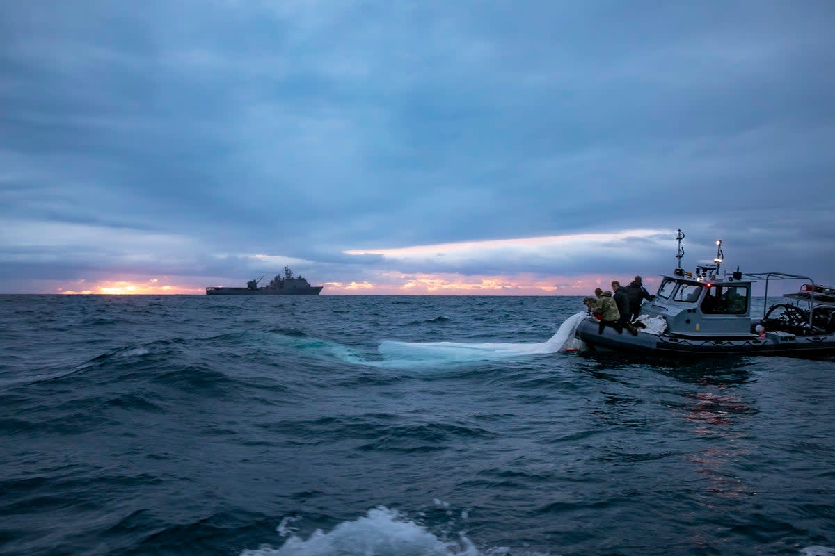 Spy balloon recovery: An image released by the US Navy shows sailors with the Explosive Ordnance Disposal Group recover what the Pentagon has described as a “high-altitude surveillance balloon” off the coast of Myrtle Beach, South Carolina, Feb. 5, 2023. (Image supplied by US Navy / 1st Class Tyler Thompson )