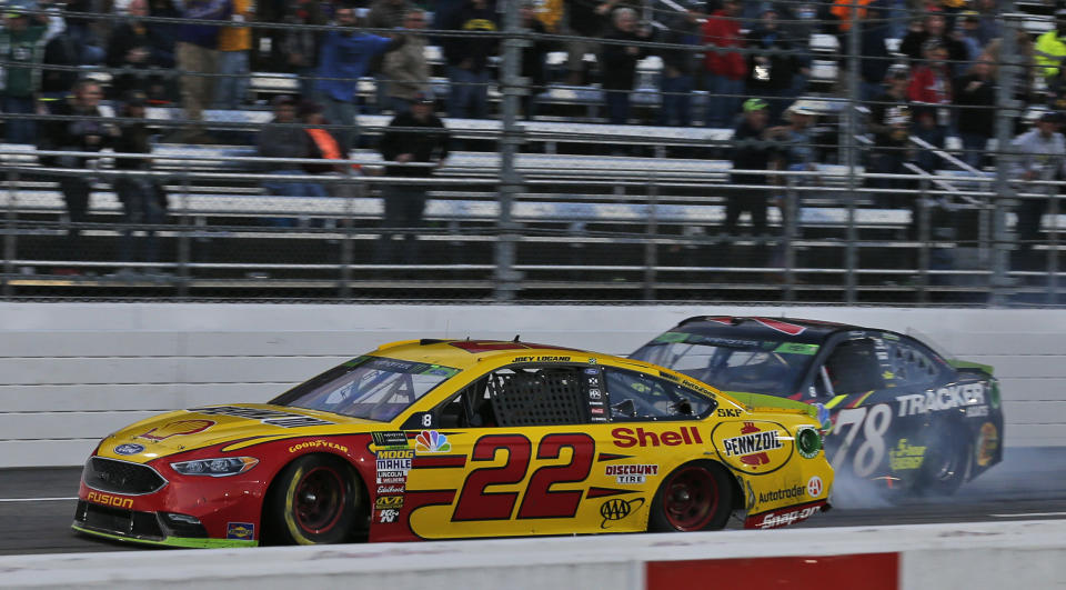 Joey Logano (22) approaches the finish line as Martin Truex Jr. (78) follows as he wins the Monster Energy NASCAR Cup Series auto race at Martinsville Speedway in Martinsville, Va., Sunday, Oct. 28, 2018. (AP Photo/Steve Helber)