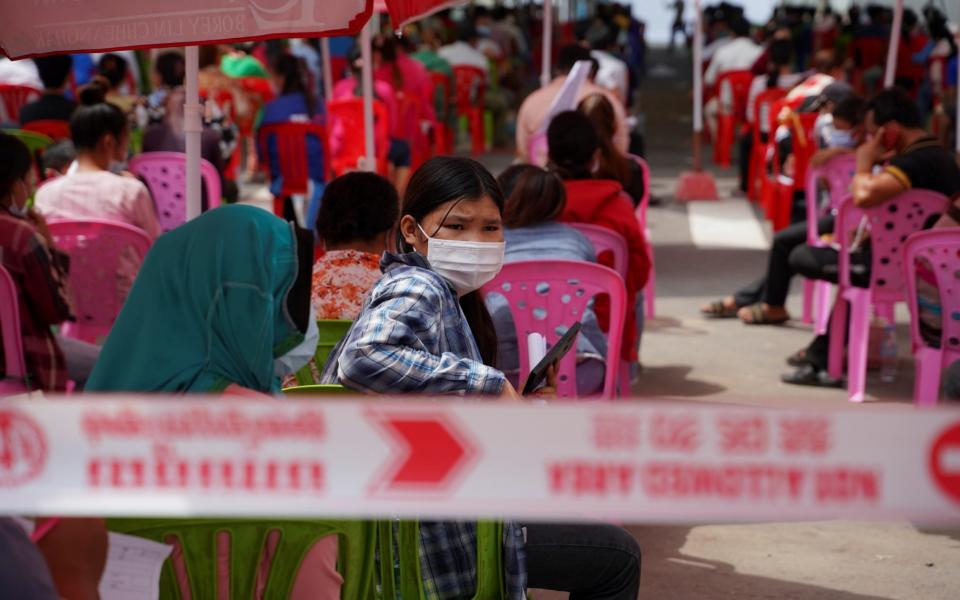 People wait to get tested inside a red zone in Phnom Penh - Reuters