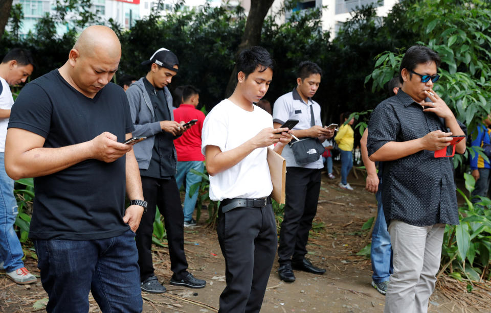 FILE PHOTO: Filipinos use their mobile phones at a park in Taguig, Metro Manila, Philippines, August 2, 2018. Picture taken August 2, 2018. REUTERS/Erik De Castro