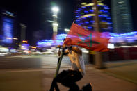 A fan rides a scooter carrying a flag of Morococo in Doha, Qatar, Tuesday, Dec. 6, 2022, after Morocco defeated Spain in a penalty shootout in a World Cup soccer match and qualified to the quarterfinals.