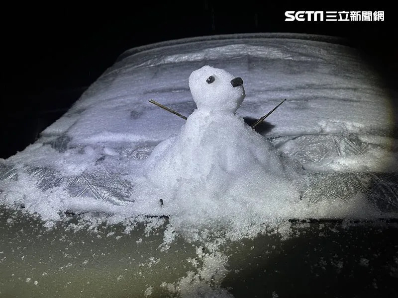 睡到一半被爸媽挖起來的小朋友，也應景的在車上堆雪人。（圖／記者羅欣怡攝影）