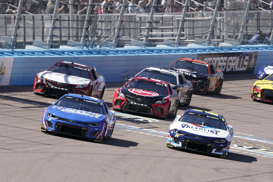 Kyle Larson, izquierda, y William Byron, derecha, lideran después de la primera vuelta durante la carrera de autos de la NASCAR Cup Series en Phoenix Raceway, el domingo 12 de marzo de 2023, en Avondale, Arizona. (Foto AP/Darryl Webb)