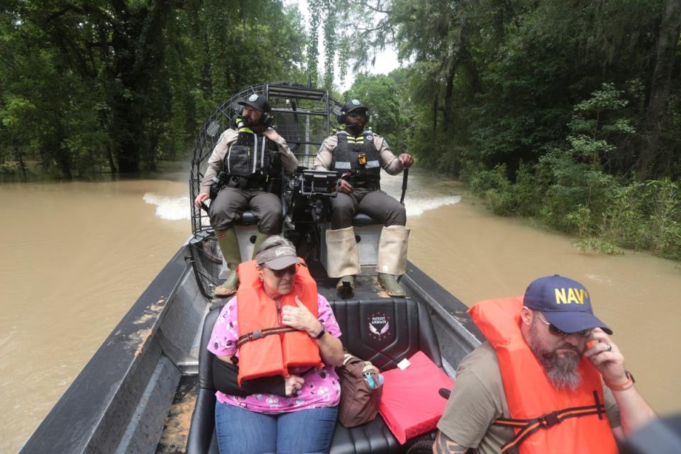Texas Parks & Wildlife Department game wardens use a boat to rescue residents from floodwaters in Liberty County, Texas, on Saturday (AP)