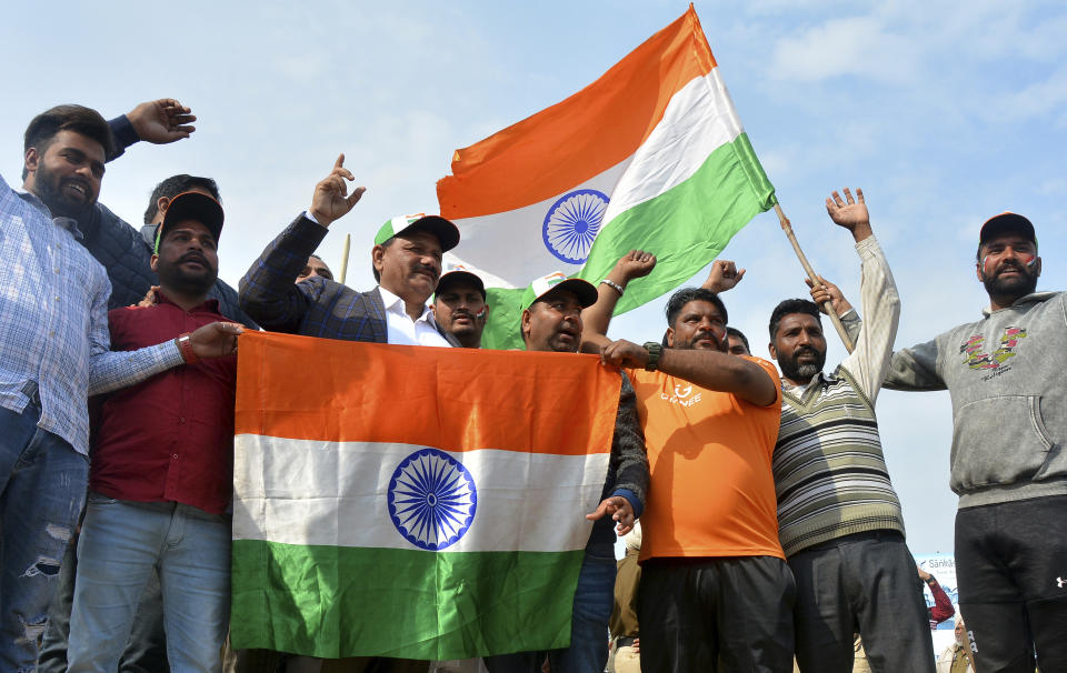 Indians hold national flags and shout slogan as they wait to welcome Indian pilot at India Pakistan border at Wagah, 28 kilometers (17.5 miles) from Amritsar, India, Friday, March 1, 2019. Pakistan is preparing to hand over a captured Indian pilot as shelling continued for a third night across the disputed Kashmir border even as the two nuclear-armed neighbors seek to defuse the most serious confrontation in two decades. (AP Photo/Prabhjot Gill)