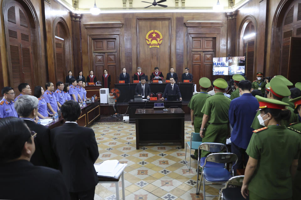 People stand before Vietnamese real estate tycoon Truong My Lan enters a courtroom in Ho Chi Minh City, Vietnam on Tuesday, March 5, 2024. Lan faces the death penalty in a trial that began Tuesday over alleged fraud amounting to $12.5 billion, nearly 3% of the country’s 2022 GDP. (Phan Thanh Vu/VNA via AP)