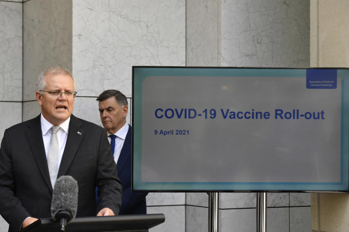 Australian Prime Minister Scott Morrison, left, addresses the media at a press conference as Department of Health Secretary Dr Brendan Murphy watches at Parliament House in Canberra, Australia, Friday, April 9, 2021. Australia says it has finalized a deal to buy an extra 20 million doses of the Pfizer vaccine as the nation rapidly pivots away from its earlier plan to rely mainly on the AstraZeneca vaccine. (Mick Tsikas/AAP Image via AP)