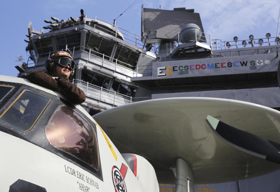 In this Monday, March 20, 2017 photograph, the pilot of an E-2C Hawkeye watches flight operations on the USS George H.W. Bush as it travels toward the Strait of Hormuz. The arrival of the nuclear-powered aircraft carrier to the Persian Gulf marks the first such deployment under new U.S. President Donald Trump. (AP Photo/Jon Gambrell)