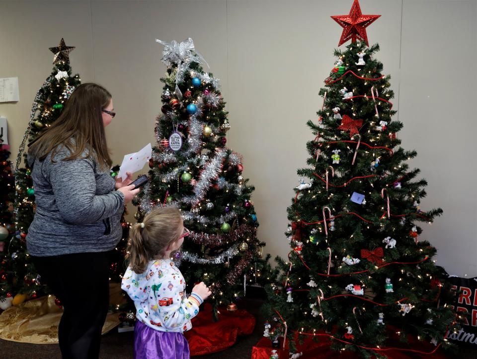 Amy Kline, with her daughter Callie, check out the trees in the Fairfield County 2-1-1 Tour of Trees during the 10th Annual WinterFest and Tree Lighting in downtown Lancaster Saturday, Dec. 4. Callie liked the tree with the dogs the best.