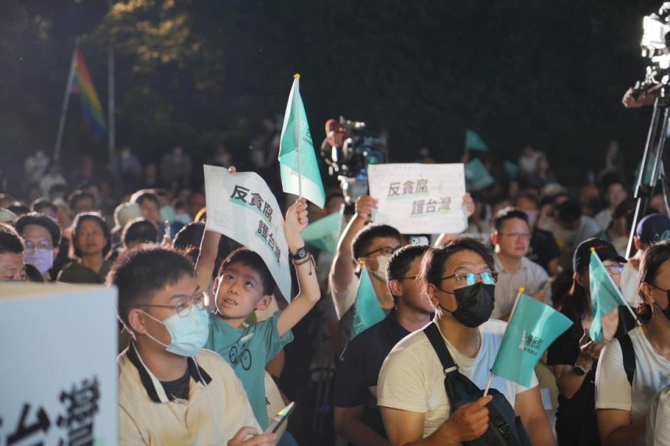 民眾黨今(22)天晚在榮星花園舉行「反貪腐、護台灣」宣講，儘管夏夜悶熱，但廣場仍聚集許多群眾，並高舉「反貪腐、護台灣」標語。   圖：擷取自台灣民眾黨臉書