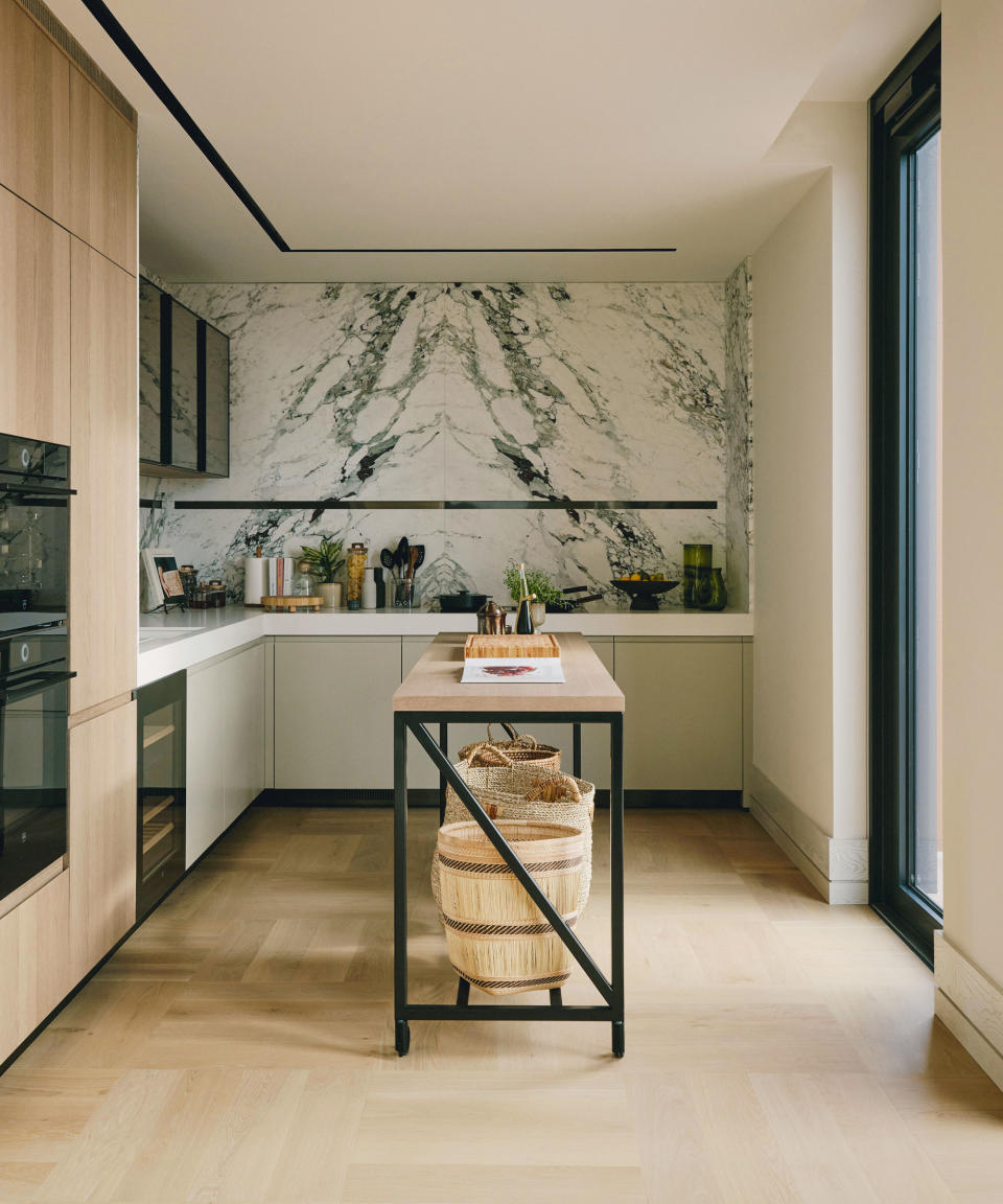 Modern kitchen with marble splashback, wooden flooring and cabinetry, sleek kitchen island