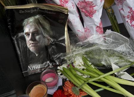 A copy of a New York Times Magazine with a photo of movie actor Philip Seymour Hoffman on the cover is pictured as part of a makeshift memorial in front of his apartment building in New York February 3, 2014. REUTERS/Carlo Allegri