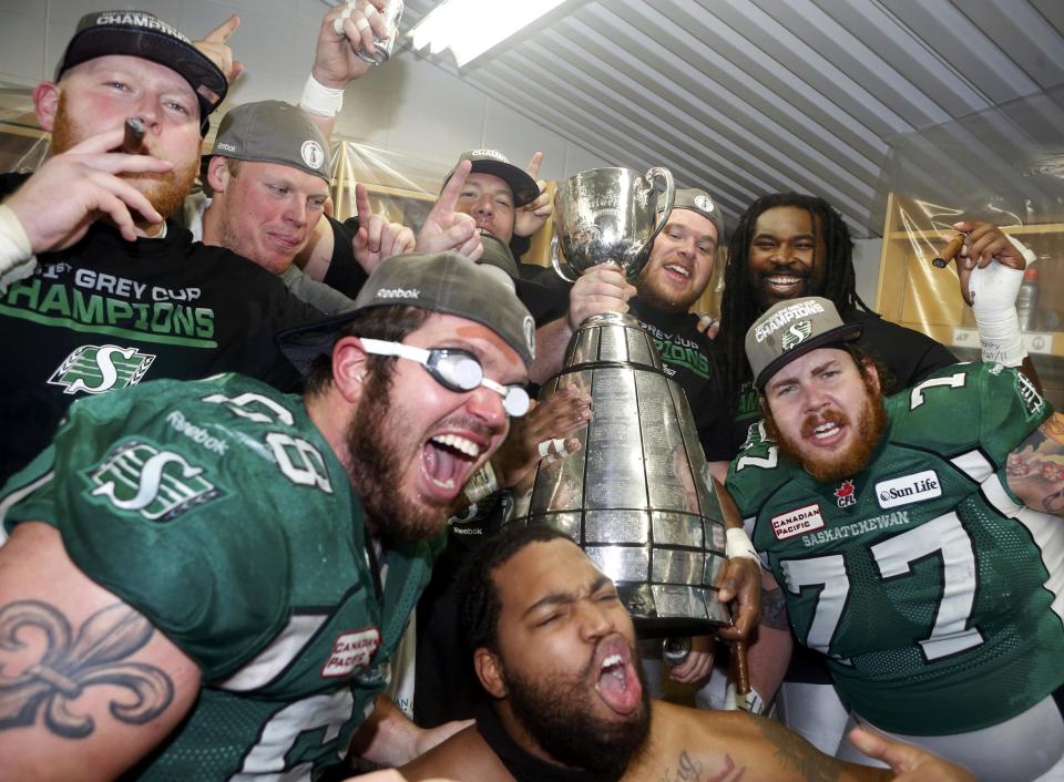 Saskatchewan Roughriders players celebrate with the Grey Cup in the dressing room after beating the Hamilton Tiger-Cats in the CFL's 101st Grey Cup championship football game in Regina, Saskatchewan November 24, 2013. REUTERS/Mark Blinch (CANADA - Tags: SPORT FOOTBALL)