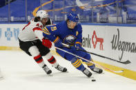 Buffalo Sabres defenseman Jake McCabe (19) and New Jersey Devils forward Miles Wood (44) battle for the puck during the first period of an NHL hockey game Saturday, Jan. 30, 2021, in Buffalo, N.Y. (AP Photo/Jeffrey T. Barnes)