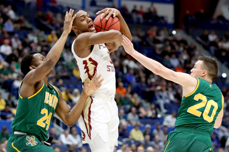 <p>Trent Forrest #3 of the Florida State Seminoles is fouled between Ben Shungu #24 and Ernie Duncan #20 of the Vermont Catamounts during their first round game of the 2019 NCAA Men’s Basketball Tournament at XL Center on March 21, 2019 in Hartford, Connecticut. (Photo by Rob Carr/Getty Images) </p>