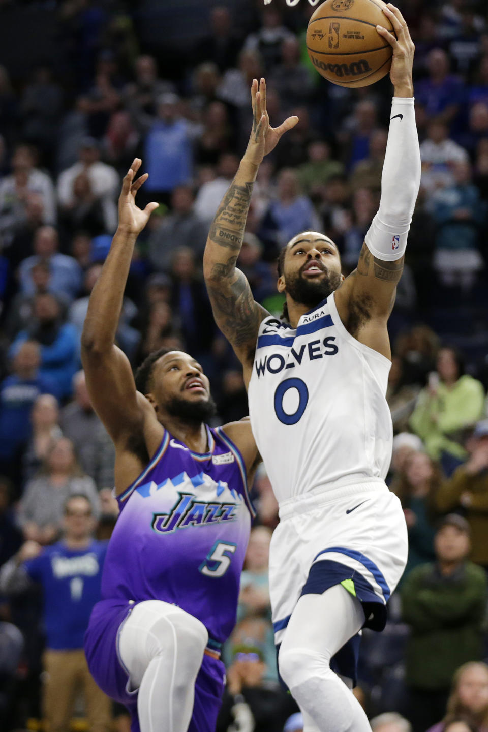 Minnesota Timberwolves guard D'Angelo Russell (0) shoots over Utah Jazz guard Malik Beasley (5) in the third quarter during an NBA basketball game Monday, Jan. 16, 2023, in Minneapolis. (AP Photo/Andy Clayton-King)