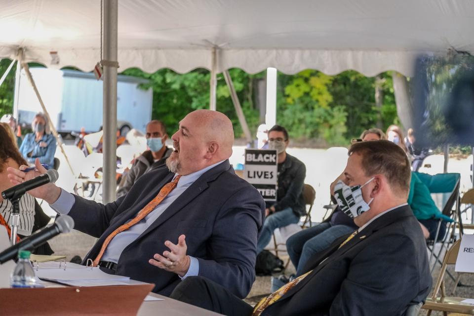 Former Grand Ledge schools Superintendent Brian Metcalf, right, with his attorney Eric Delaporte at a due process hearing in a Grand Ledge High School parking lot Monday, Sept. 21, 2020. The school district's Board of Education unanimously voted to terminate his employment during the hearing.