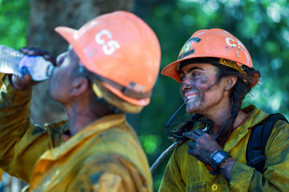 Members of the Little Tujunga Hot Shots take a break after fighting the Willow Fire near the Tassajara Zen Mountain Center in Carmel Valley, Calif., Wednesday, June 23, 2021. (AP Photo/Nic Coury)