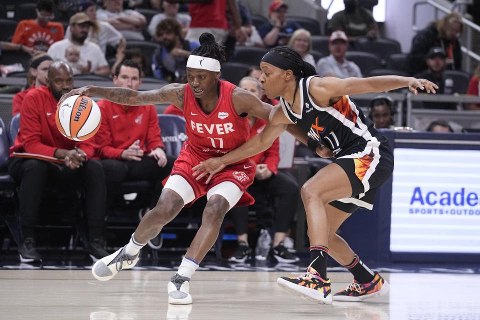 Indiana Fever's Erica Wheeler (17) is defended by Phoenix Mercury's Shey Peddy during the first half of a WNBA basketball game, Tuesday, Aug. 1, 2023, in Indianapolis. (AP Photo/Darron Cummings)