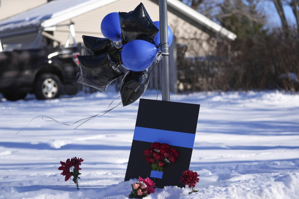 FILE - A makeshift memorial is seen near the scene where two police officers and a first responder were shot and killed, Feb. 18, 2024, in Burnsville, Minn. A woman has been charged with illegally buying guns used in the killings of the three Minnesota first responders in a standoff at a home in Burnsville, where seven children were inside, U.S. Attorney Andrew M. Luger announced Thursday, March 14, at a news conference. (AP Photo/Abbie Parr, File)