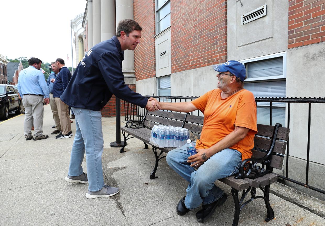 Gov. Andy Beshear, left, greeted Hazard resident Gordon Fugate outside the Perry County Emergency Operations Center in Hazard, Ky. on July 31, 2022. The governor had just finished updating the media on recovery efforts in the region following devastating flooding.