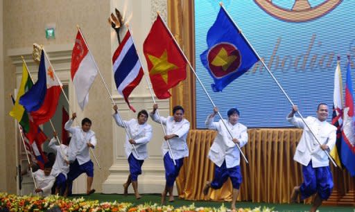 Performers carry flags of ASEAN member countries during a ceremony marking the 45th anniversary of the Association of Southeast Asian Nations (ASEAN) and its 20th summit in Phnom Penh on April 3, 2012. Southeast Asian leaders are expected Wednesday to issue a formal call for the West to ease sanctions on Myanmar