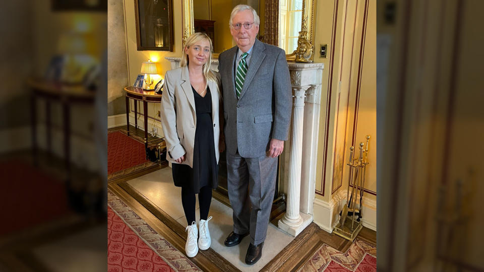 Oleksandra Ustinova poses for a picture with Sen. Mitch McConnell beside an ornate, columned fireplace below a gilded mirror.. (Courtesy of Oleksandra Ustinova)