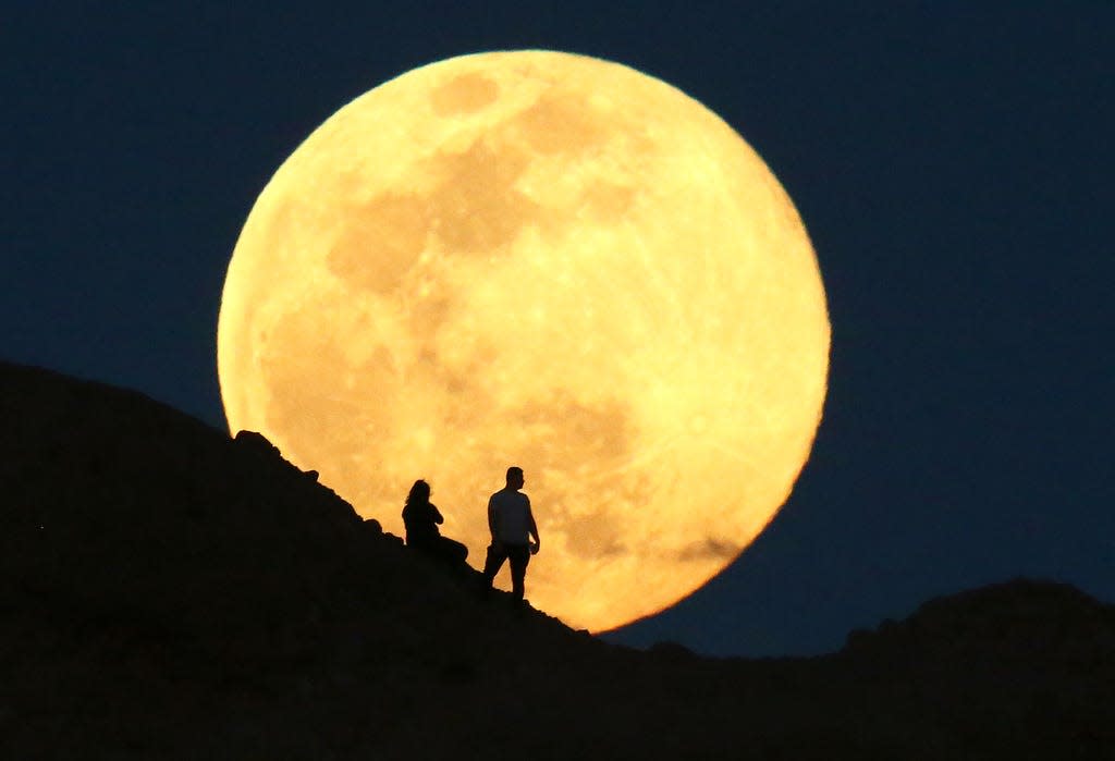 The "pink moon" rises over the Papago Park Buttes on April 7, 2020.