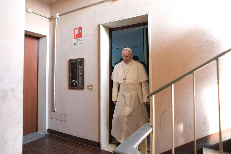 Pope Francis walks out of an apartment during his visit at Milan's Forlanini neighborhood known as Case Bianche (white houses), as part of his one-day pastoral visit to Monza and Milan, Italy’s second-largest city, Saturday, March 25, 2017. The pope's first stop Saturday is a housing project on the outskirts of Italy's fashion and finance capital, a stop that underlines the pope's view that the peripheries offer a better view of reality than well-tended and prosperous city centers. (L'Osservatore Romano/Pool Photo via AP)