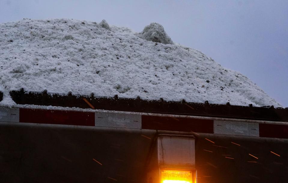 A plow truck pulls a trailer full of salt Wednesday, Feb. 2, 2022, at the Indiana Department of Transportation in Indianapolis. 