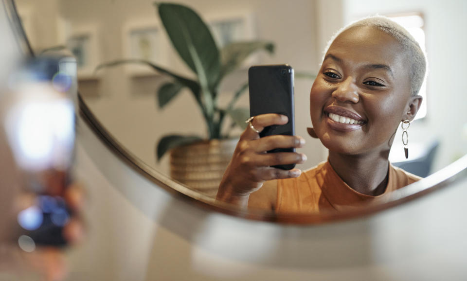 Young woman taking a mirror selfie